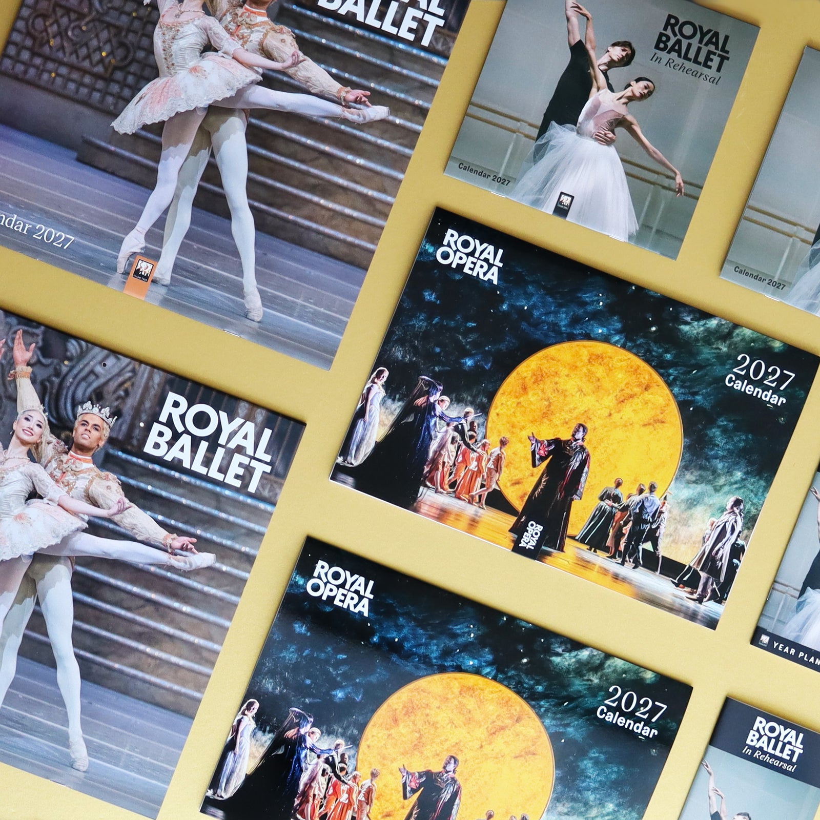 A collage of ballet and opera-themed calendar covers on a yellow gold background, featuring dancers, stage scenes, and the text 'Royal Ballet' and 'Royal Opera' '2027 Calendar'.
