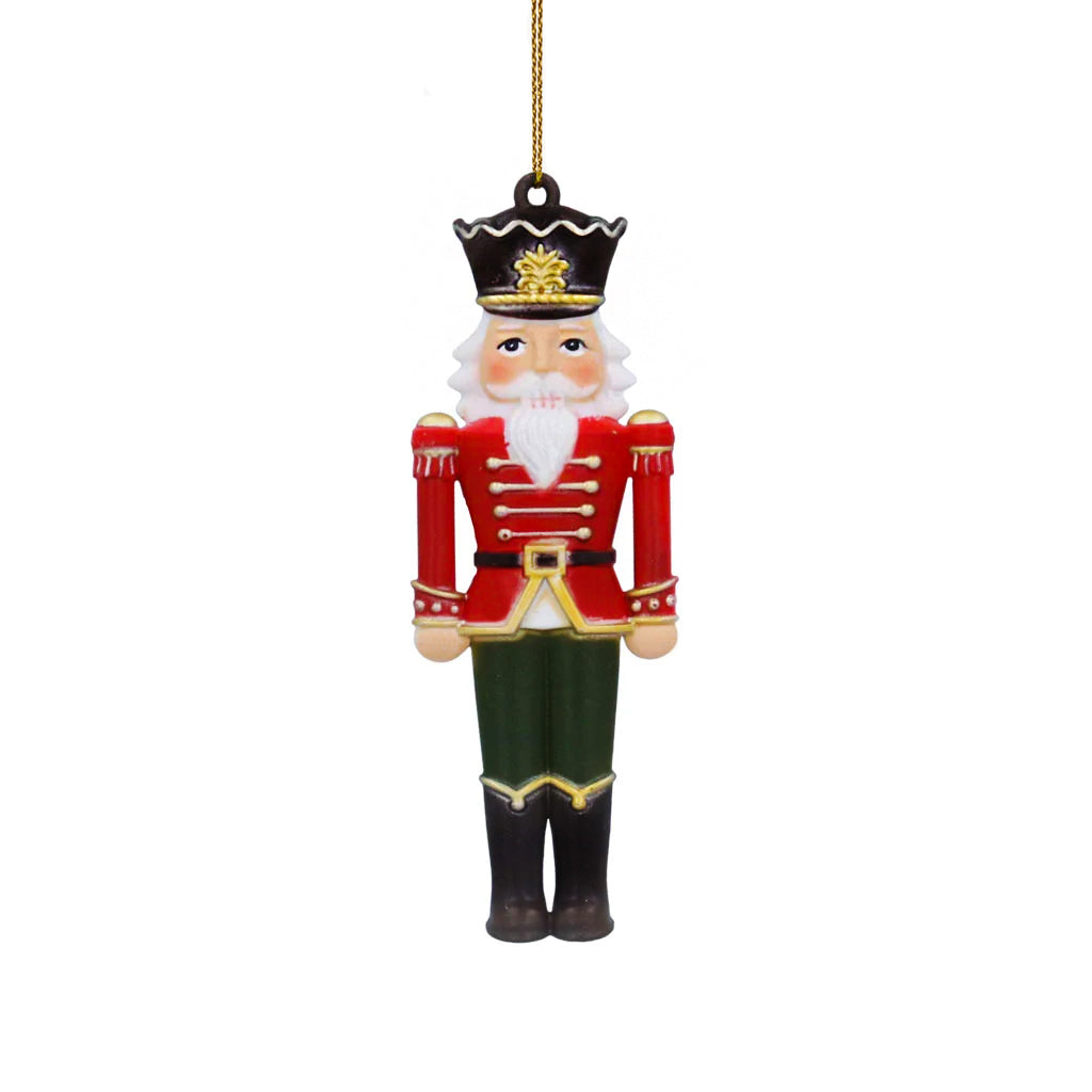 nutcracker soldier in a red and gold jacket, green trouser and black boots with a black and gold hat  hanging decoration on a white background