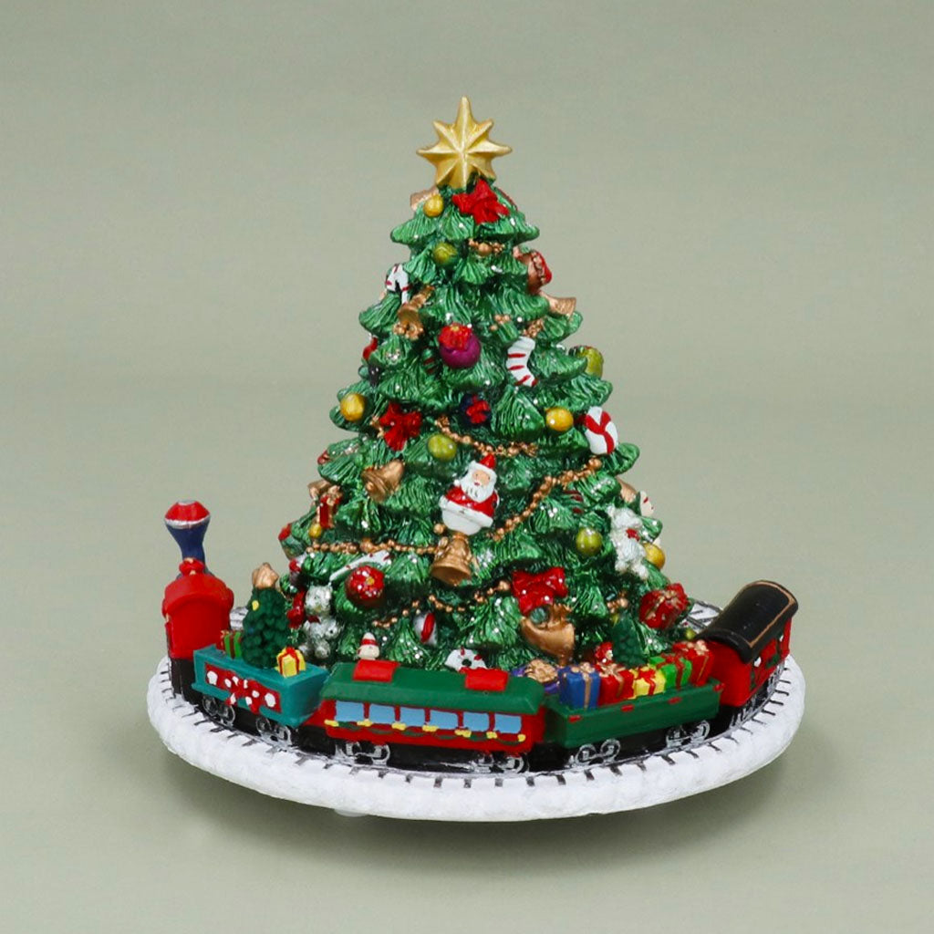 musical box in the shape of a decorated christmas tree with a toy train around the bottom on a white background