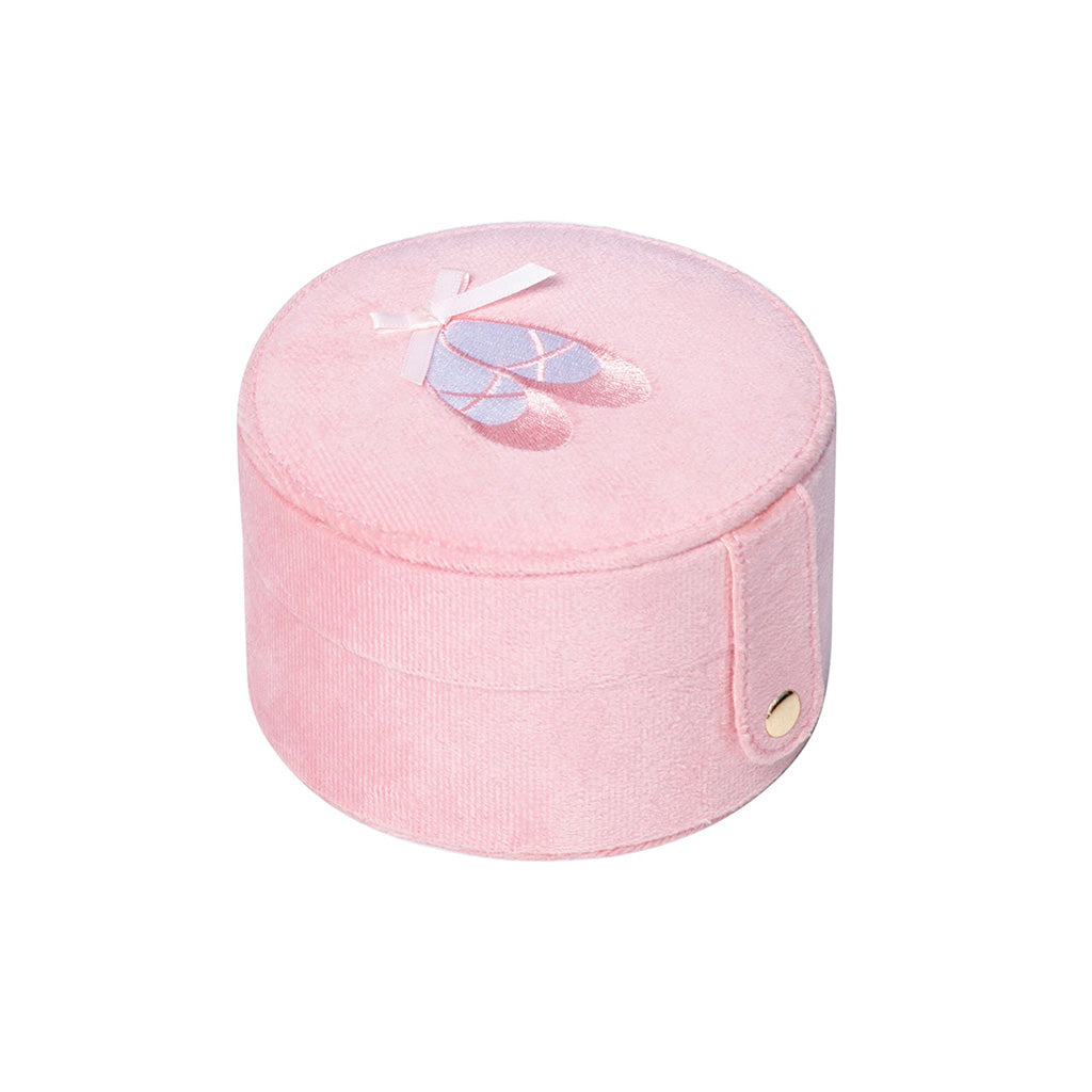 A closed Mini Ballet Jewellery Box against a white background. The box is pink and circular with a pair of pink ballet shoes embroidered on top with a small pink ribbon. The box is closed with a snap fastening attached to a strip of pink fabric. 