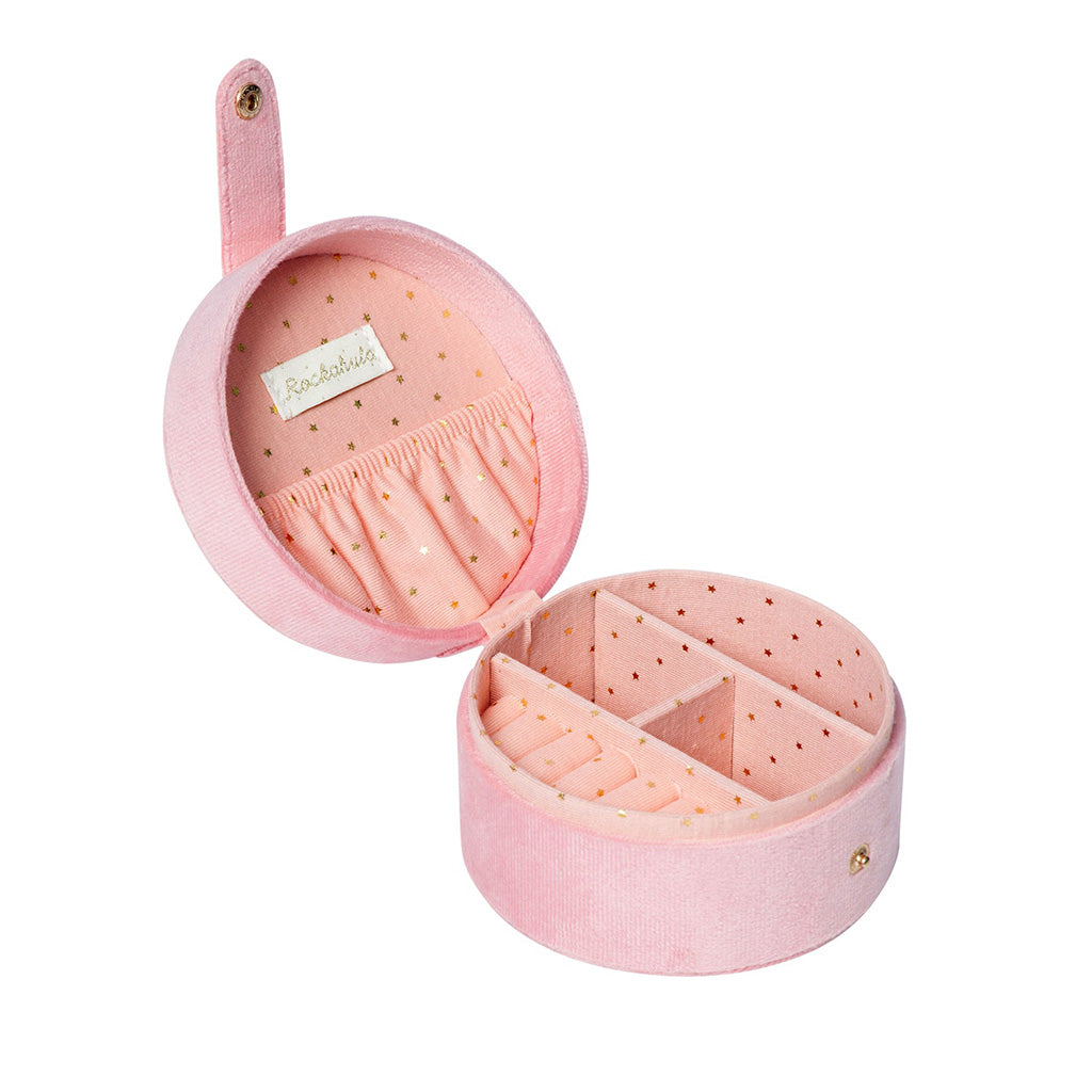 A Mini Ballet Jewellery Box by Rockahula against a white background. The box is pink and circular and is shown open to reveal a pink fabric lining with gold stars. Inside the lid is a white label with the word Rockahula written on and an elasticated pocket. There is a snap fastening attached to the lid by a piece of pink fabric. The bottom of the box is divided into 4 compartments, one of which is designed to hold rings and earrings. 