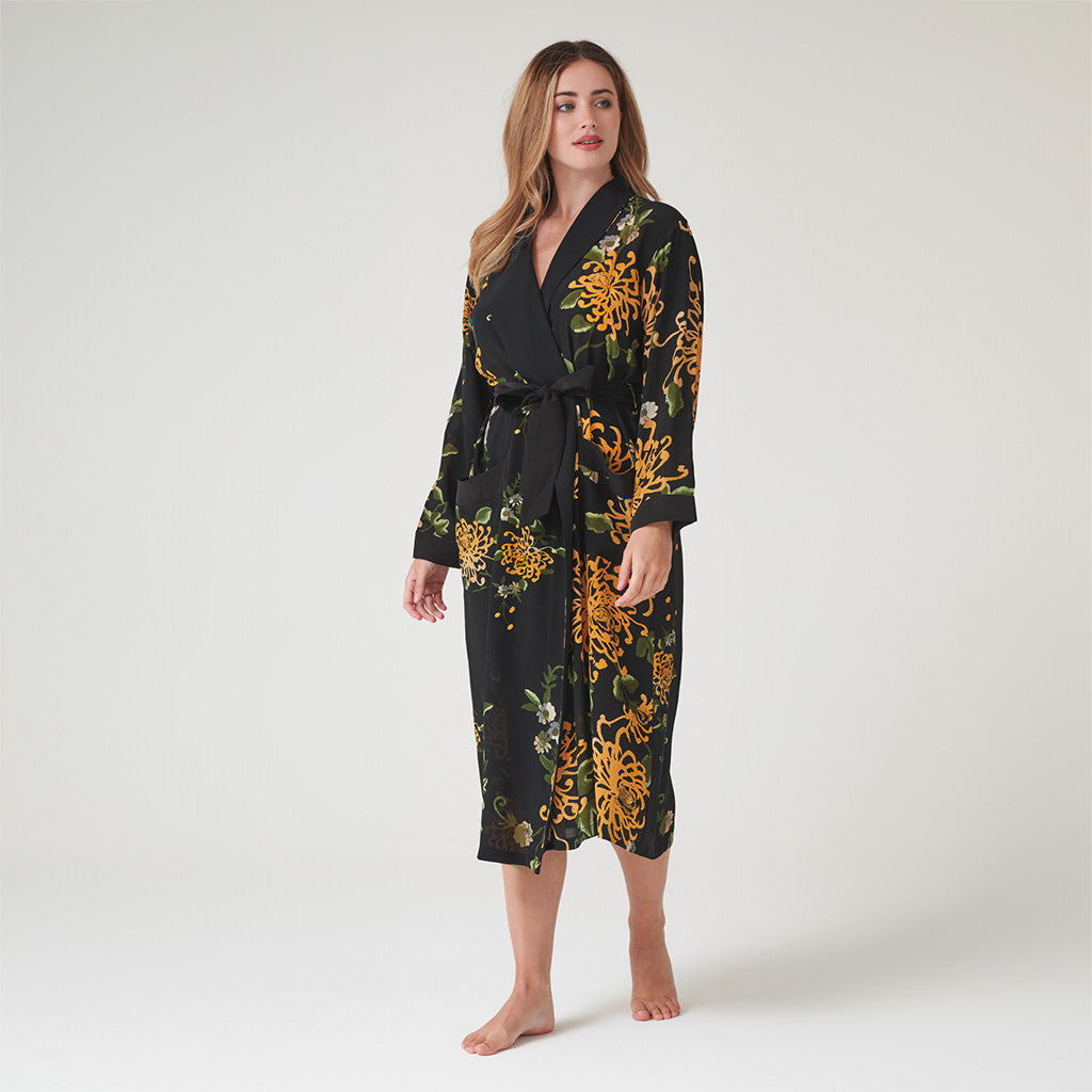 model in a Black and gold floral dressing gown on a grey
 background