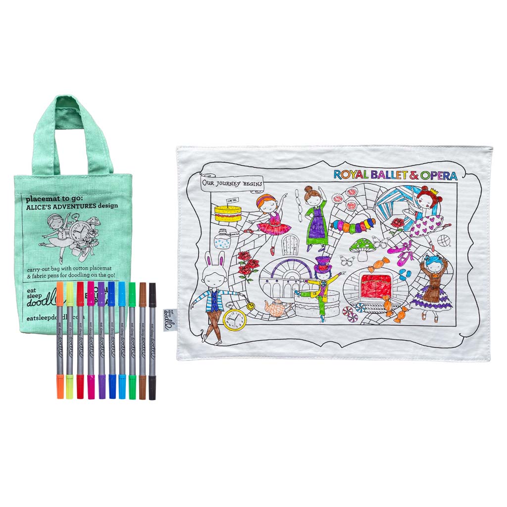An RBO Colour In Placemat with a green cloth bag and a set of ten different coloured pens. The bag is green with a white image of a girl dancing next to a stop watch and other items such as ballet shoes and a mushroom. The text on the bag reads &quot;placemat to go: Alice&#39;s Adventures design&quot;. the Placemat is white and shows a winding path along which are various characters and items from Alice&#39;s Adventures in wonderland. Some have been coloured in but the rest of the image is white with black line work.