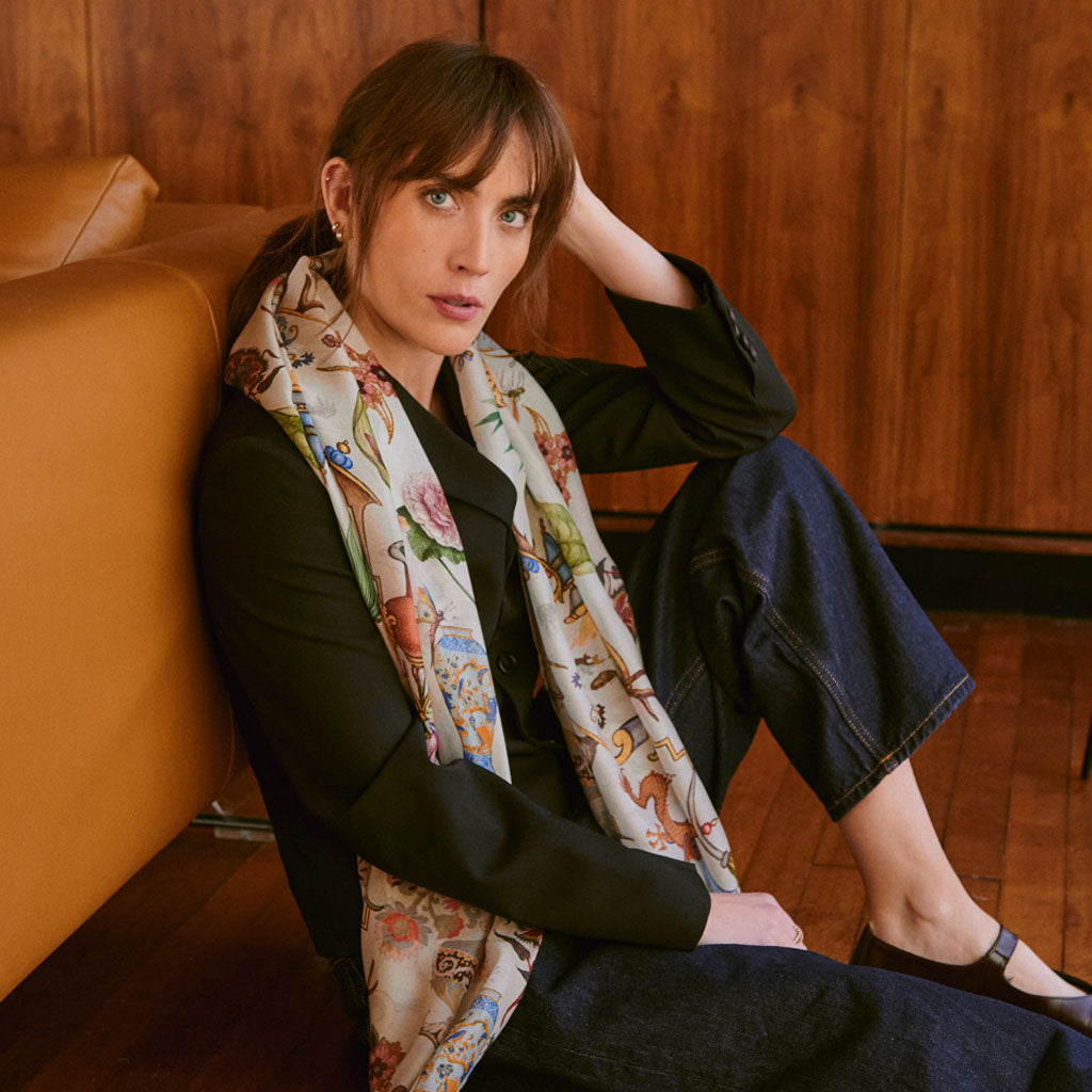 model wearing the Cornucopia Scarf sitting with her back to a tan sofa