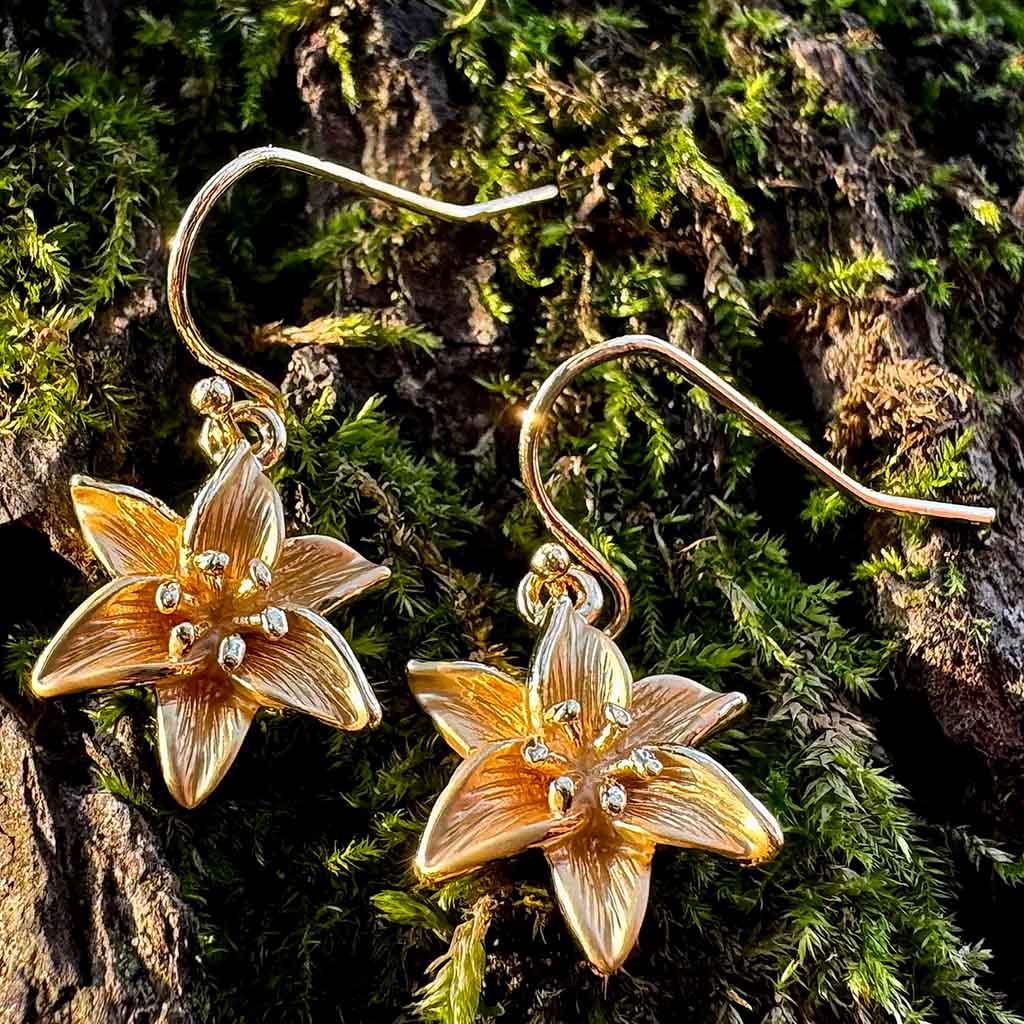 Pair of gold flower-shaped earrings on a white background