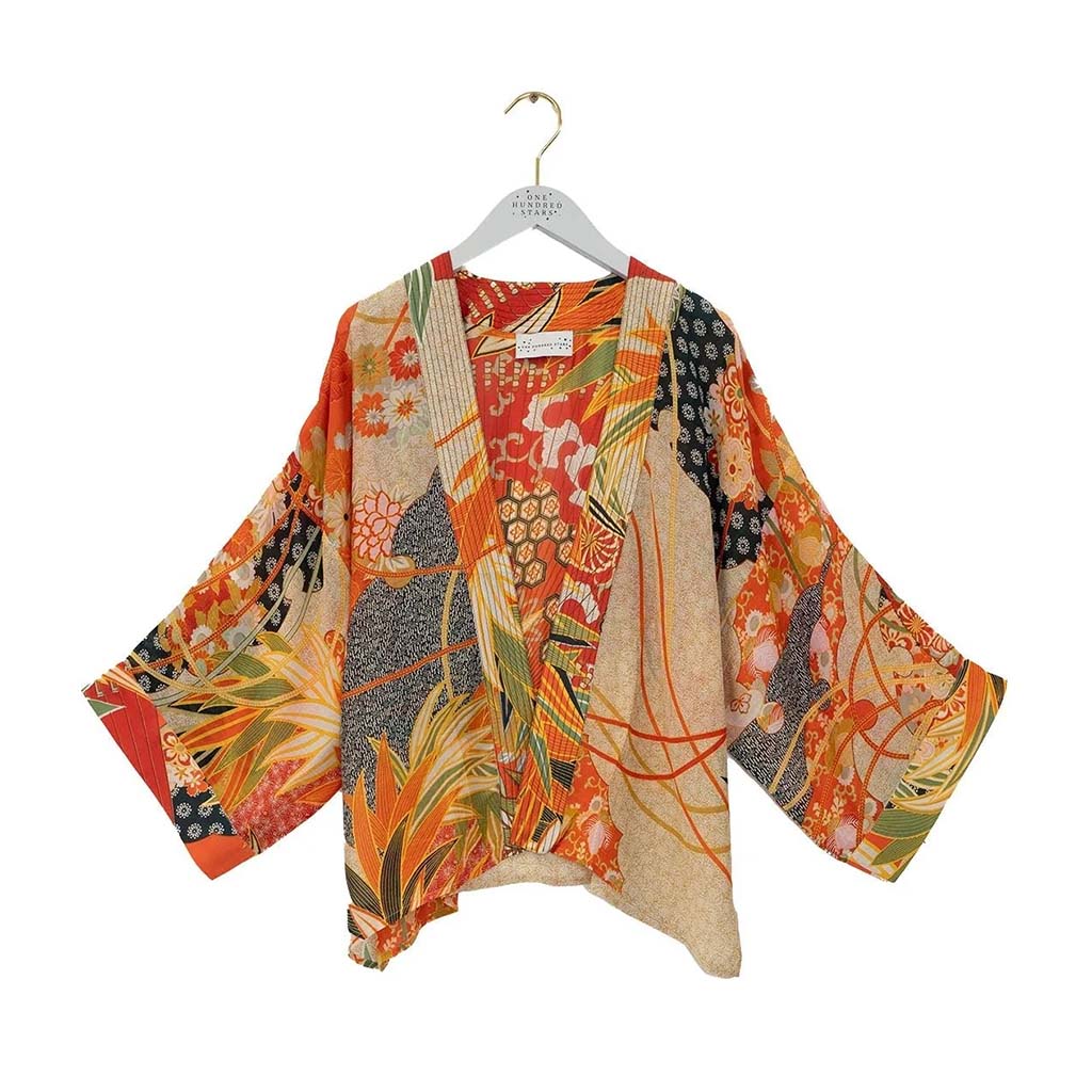 Colourful kimono-style garment on a hanger against a white background