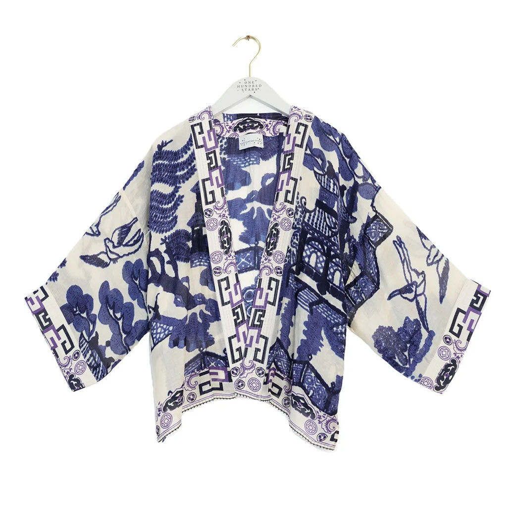 Blue and white patterned kimono on a hanger against a white background