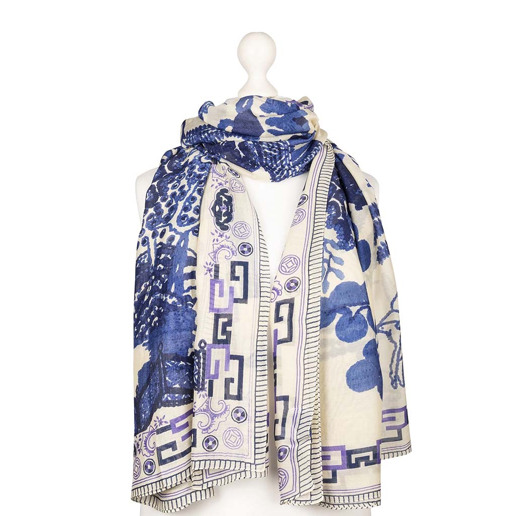 Blue and white patterned scarf on a mannequin against a white background