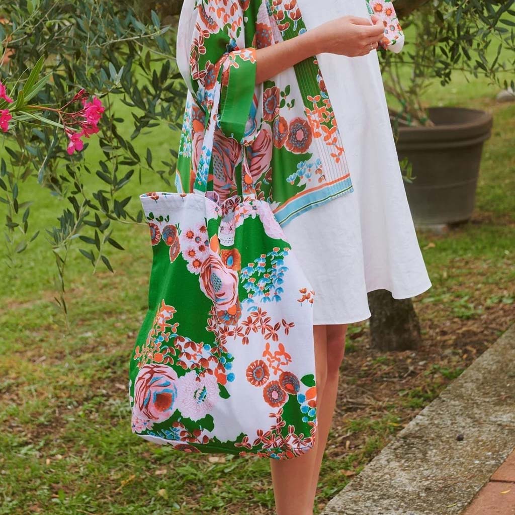 woman with a floral tote bag in a garden