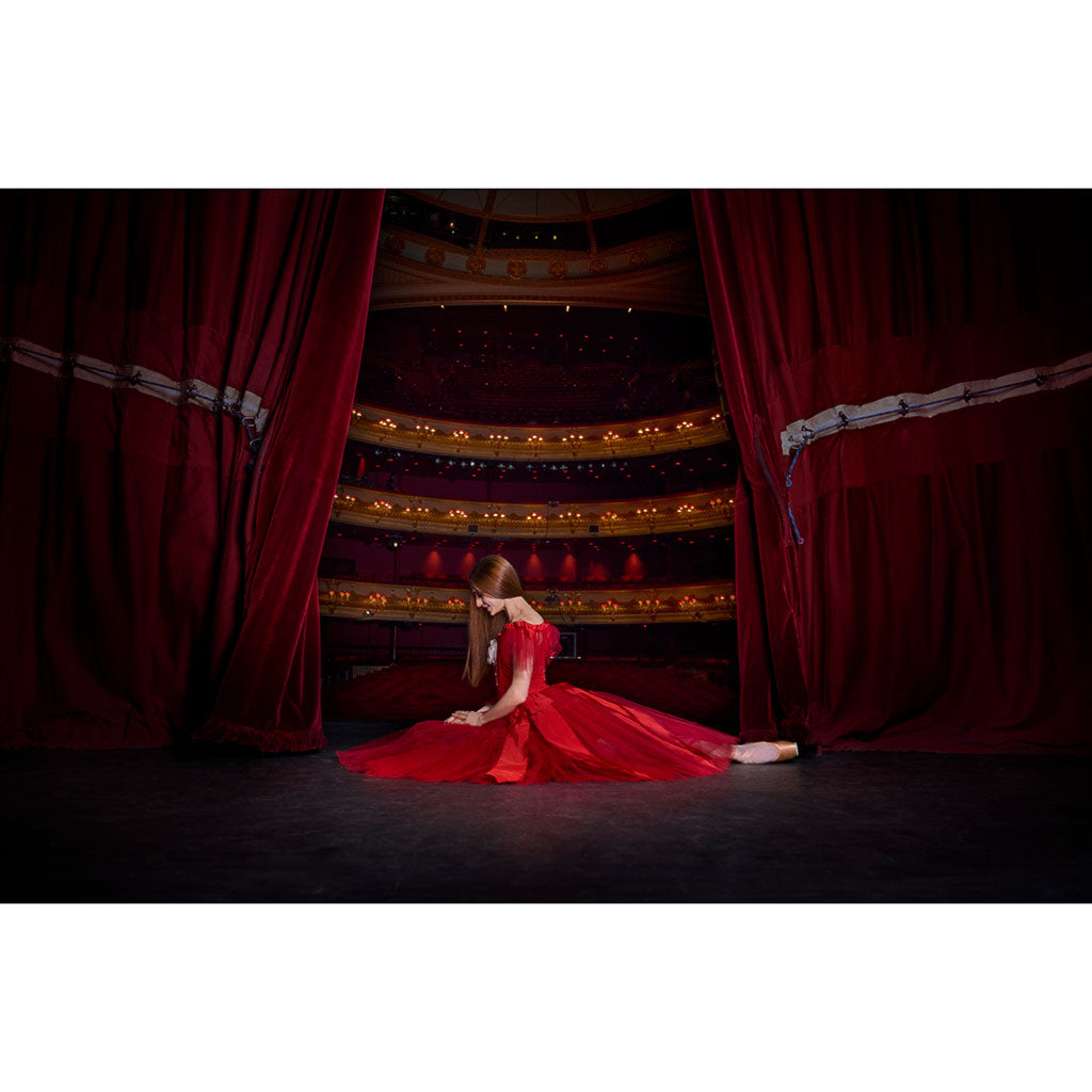 Dancer Marianela Nunez in a red dress on the RBO stage with red curtains