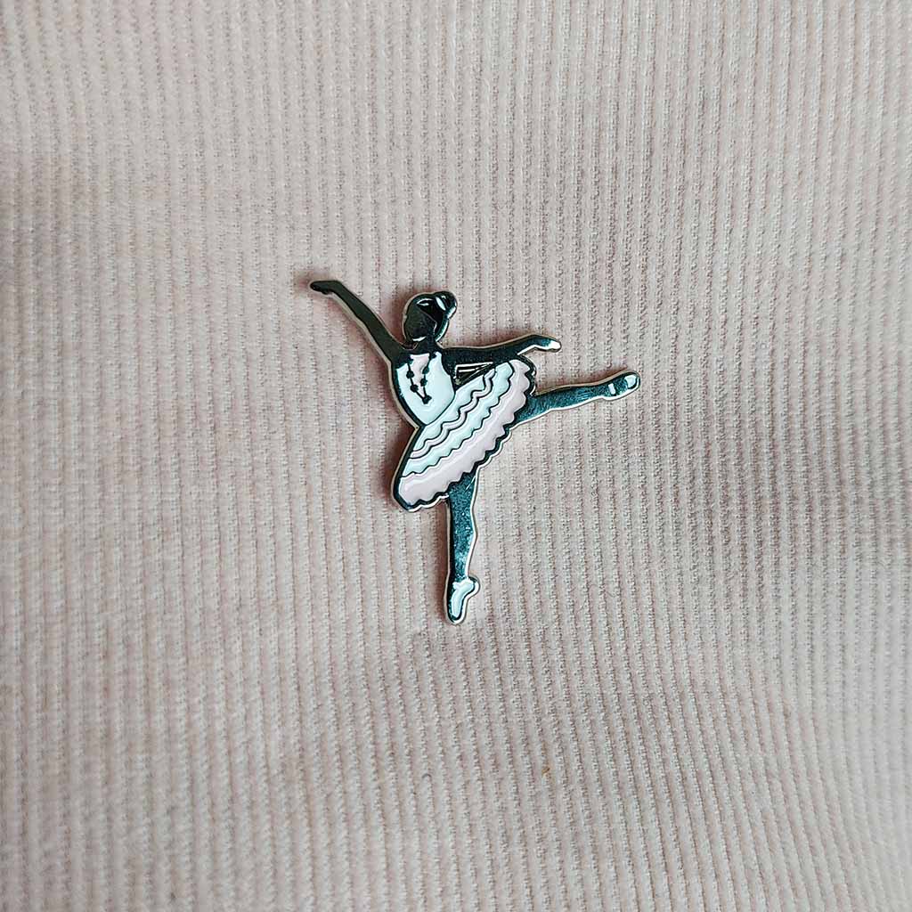 Silver ballerina pin badge with pink tutu on a white background