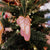 a pink beaded ballet shoe decoration  with gold trim on a white background