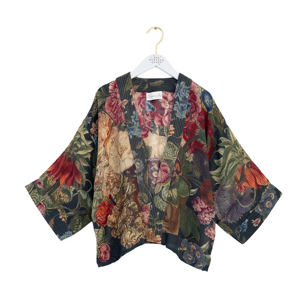 Floral patterned kimono style jacket on a hanger against a white background