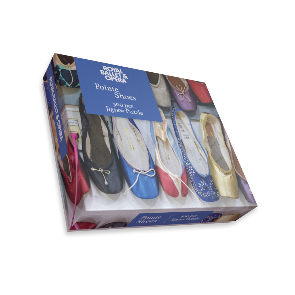 Jigsaw puzzle box featuring colour pointe shoes, on a white background