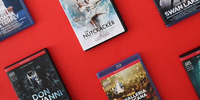Several opera and ballet Blu-ray and DVD cases arranged on a bright red background, including titles such as Swan Lake, The Nutcracker and Don Giovanni