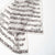 White scarf with black musical notes and text on a white background