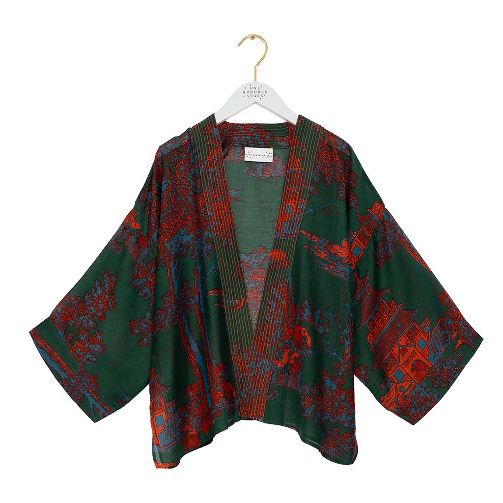 Green and orange pagoda patterned kimono on a white hanger against a white background