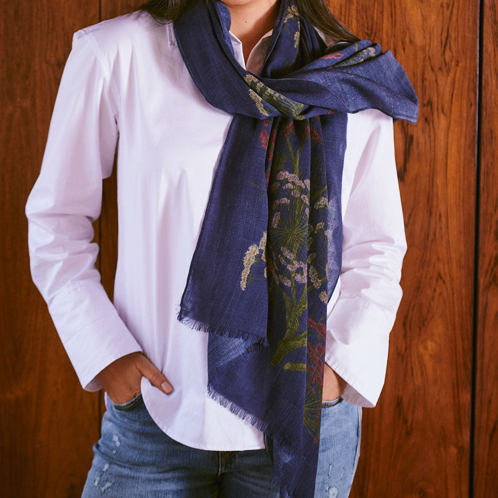 model wearing a blue Parsley Seed patterned Scarf against a wood panelled background