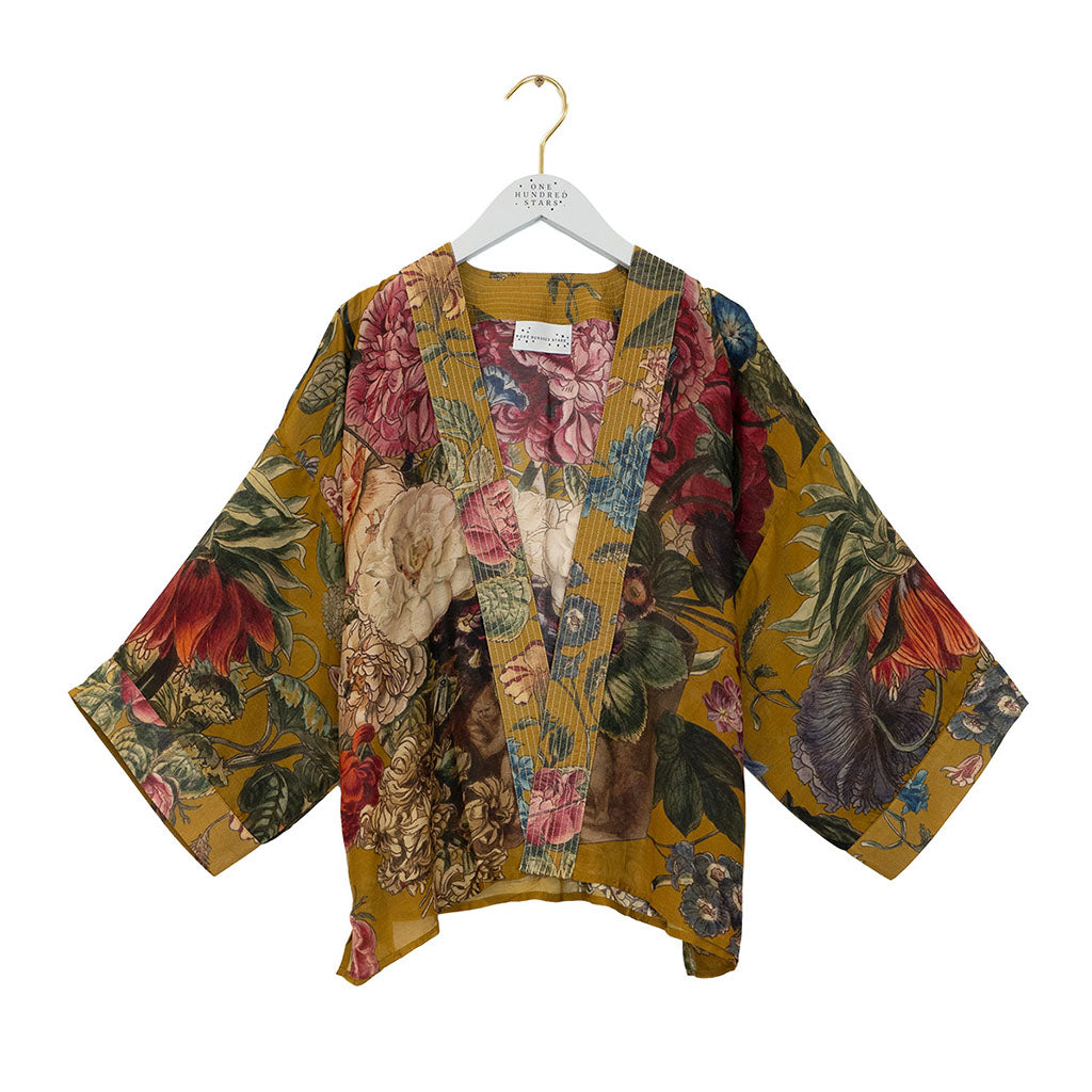 Gold floral design kimono style jacket on a hanger on a white background