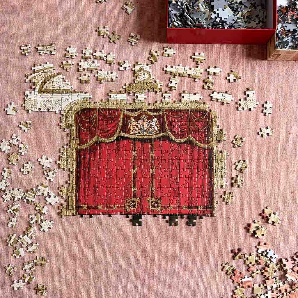 Jigsaw puzzle of the auditorium curtain with missing pieces on a pink background