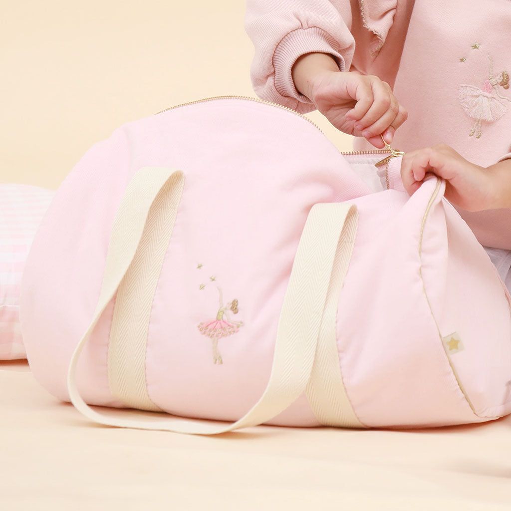 Pink ballerina duffel bag with cream handles on a white background