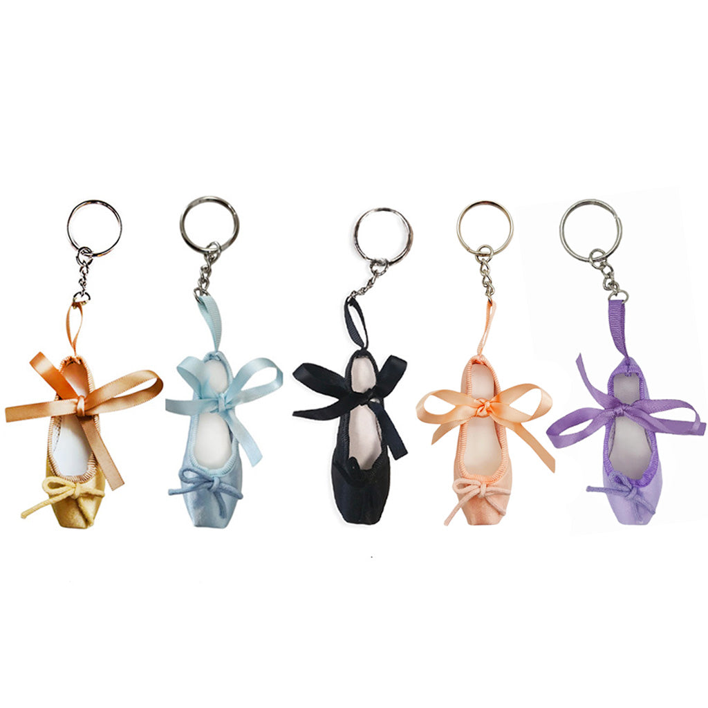 Five ballet shoe keyrings with colourful ribbons on a white background