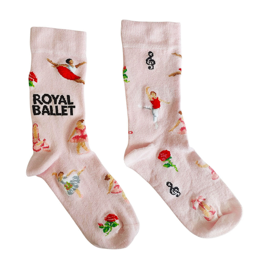 A pair of light pink bamboo socks featuring ballerina dancers, musical notes, roses, ballet shoes, flowers and the text 'ROYAL BALLET' on a white background.