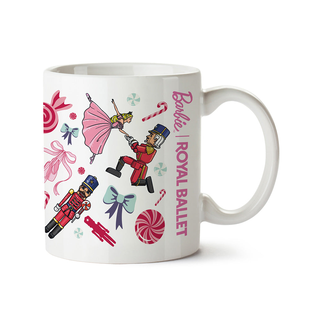 A white ceramic mug featuring a colourful 'Barbie Royal Ballet' holiday-themed illustration with nutcrackers, a ballerina, candy canes, bows, and peppermint candies, set against a plain white background.