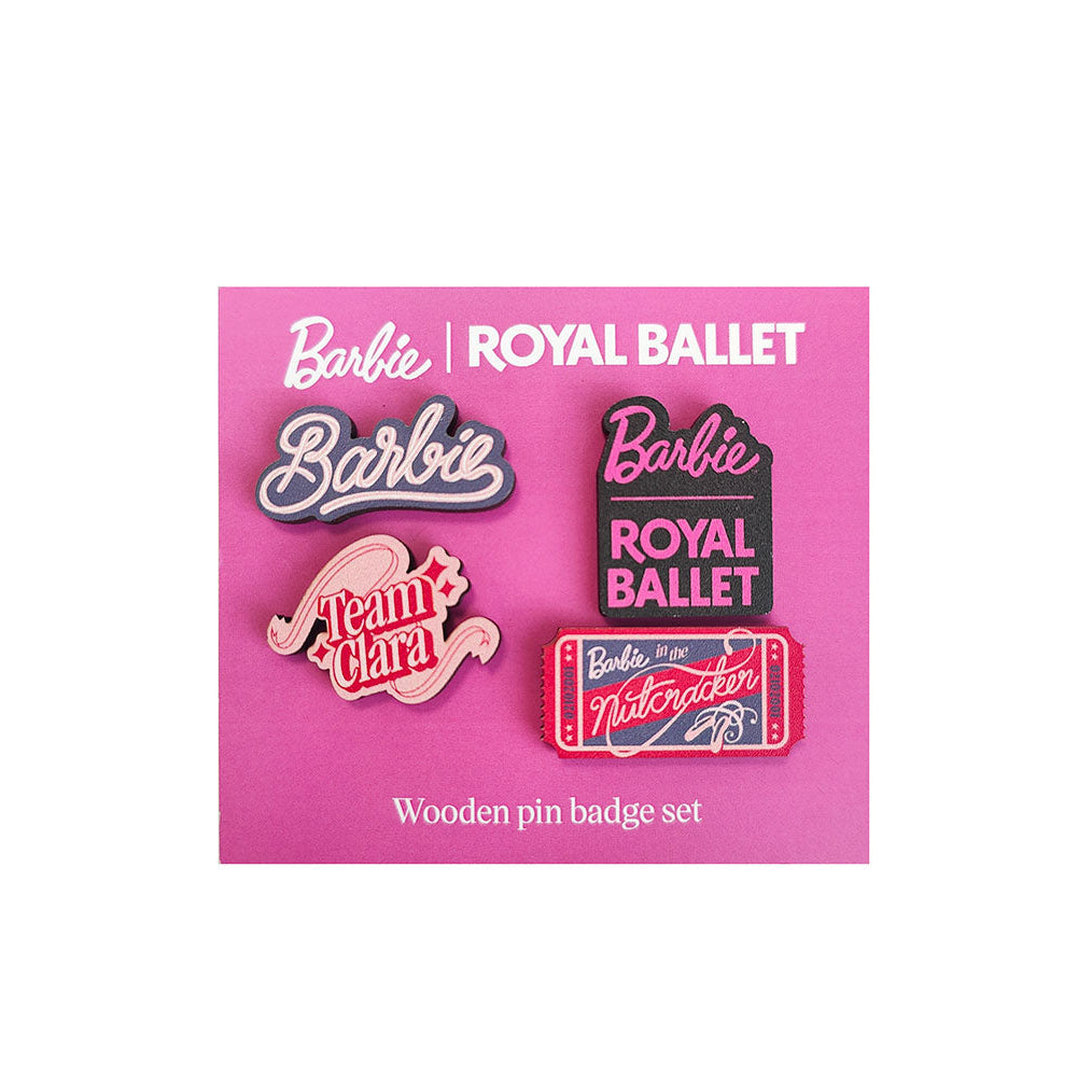 A set of four wooden Barbie pin badges displayed on a bright pink backing card. The badges feature designs including 'Barbie', 'Team Clara', 'Barbie - Royal Ballet', and a ticket-style badge reading 'Barbie and the Nutcracker'.