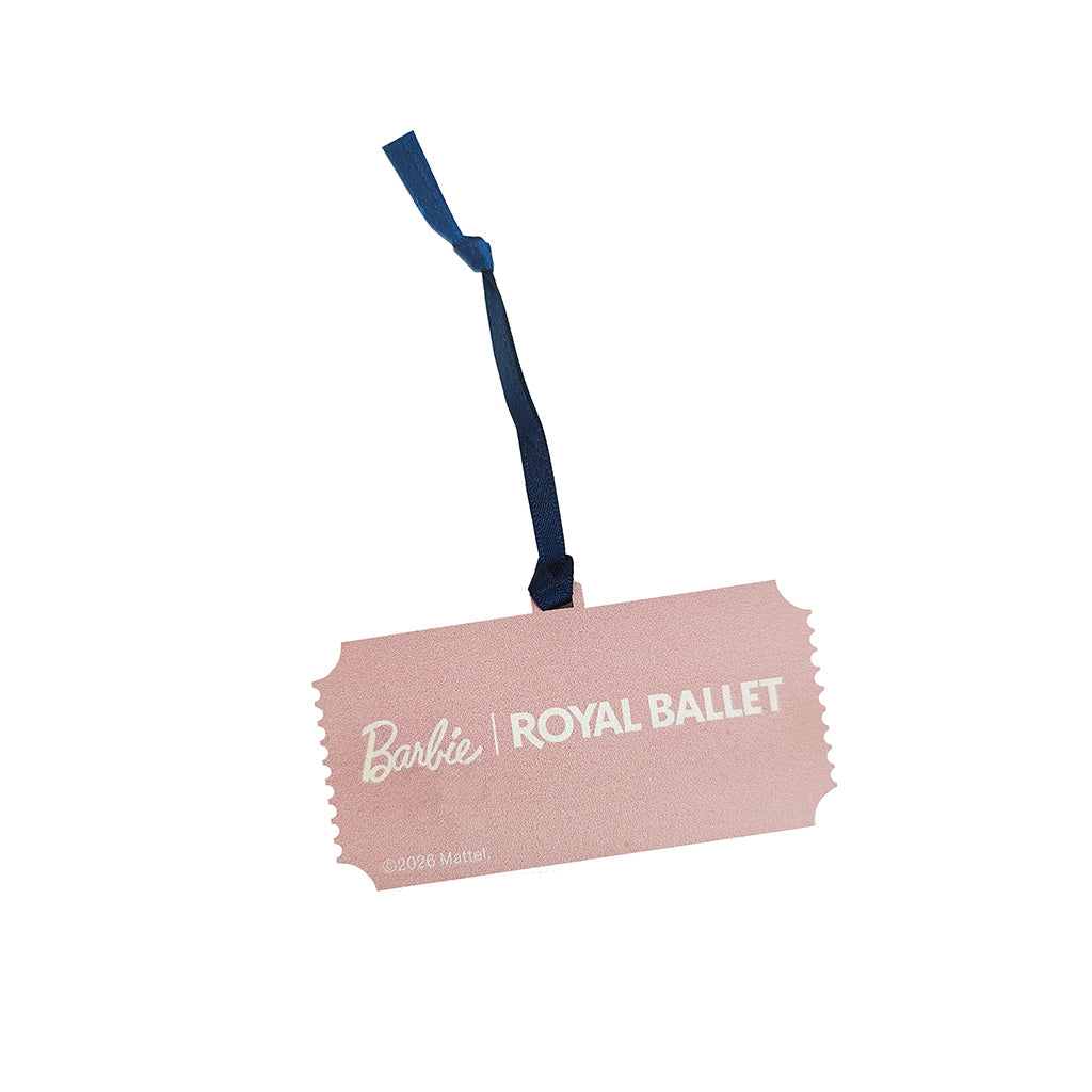 Back view of a Barbie Royal Ballet ticket-shaped decoration in a textured light pink color with a navy blue hanging ribbon, featuring the Barbie logo and 'ROYAL BALLET' text.