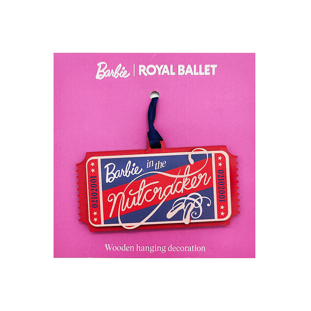 A Barbie-themed wooden hanging decoration shaped like a Nutcracker ticket, displayed on a pink backing card with the text 'Barbie | ROYAL BALLET'. The ticket features red, blue, and white colours with a dark blue hanging loop.