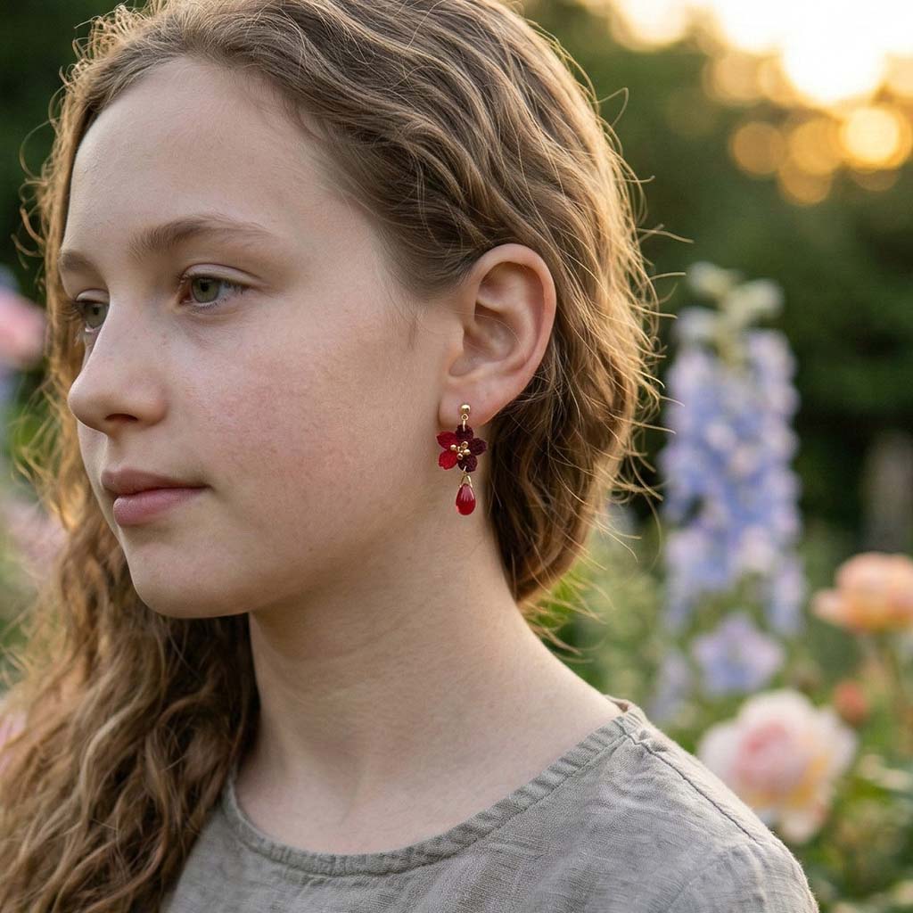 model wearing red crochet flower  earrings in a garden