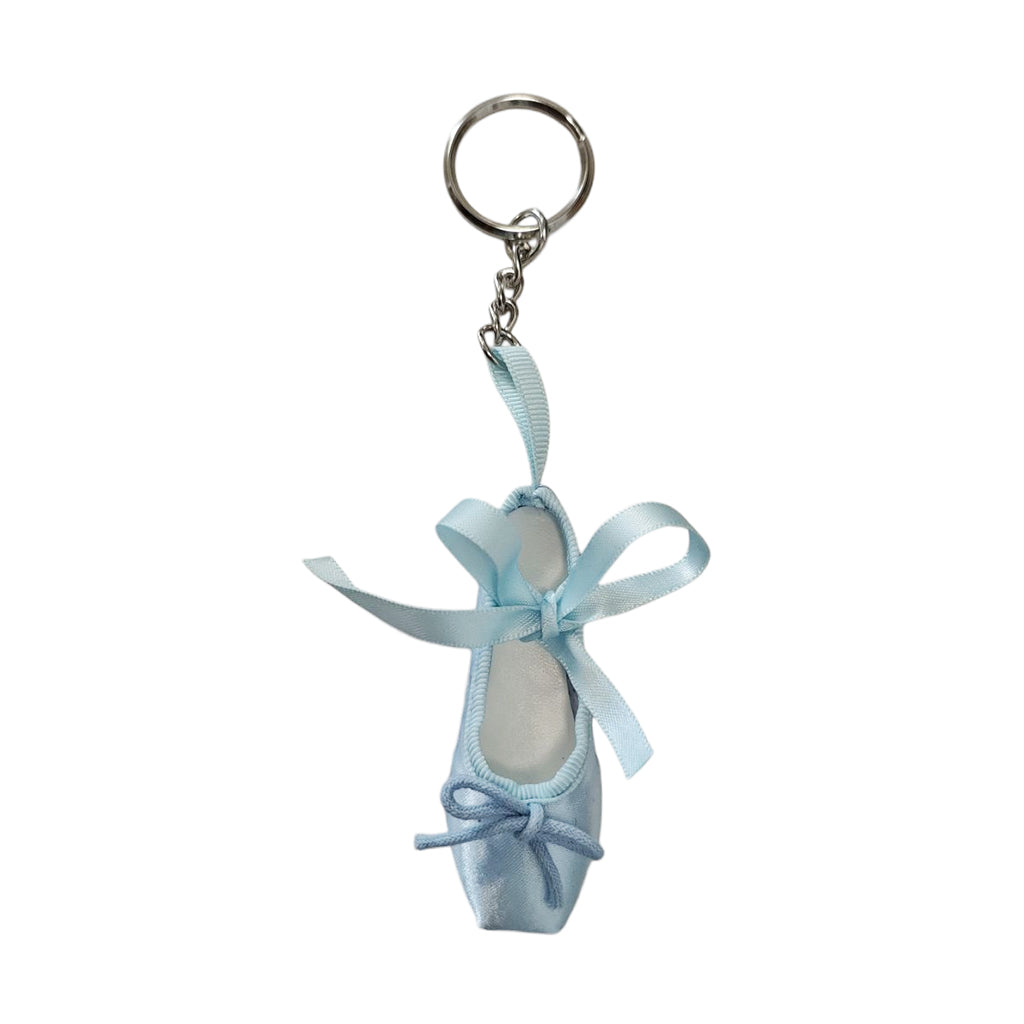 A blue keyring in the shape of a ballet shoe against a white background. The keyring is hanging vertically, suspended by a short metal chain with a larger ring at the top for attaching to keys. There are two blue bows, a larger one about two thirds of the way up the shoe, and a smaller one at the bottom. 