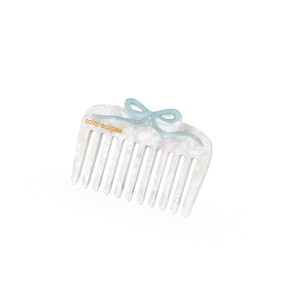 White comb with a blue bow on a white background