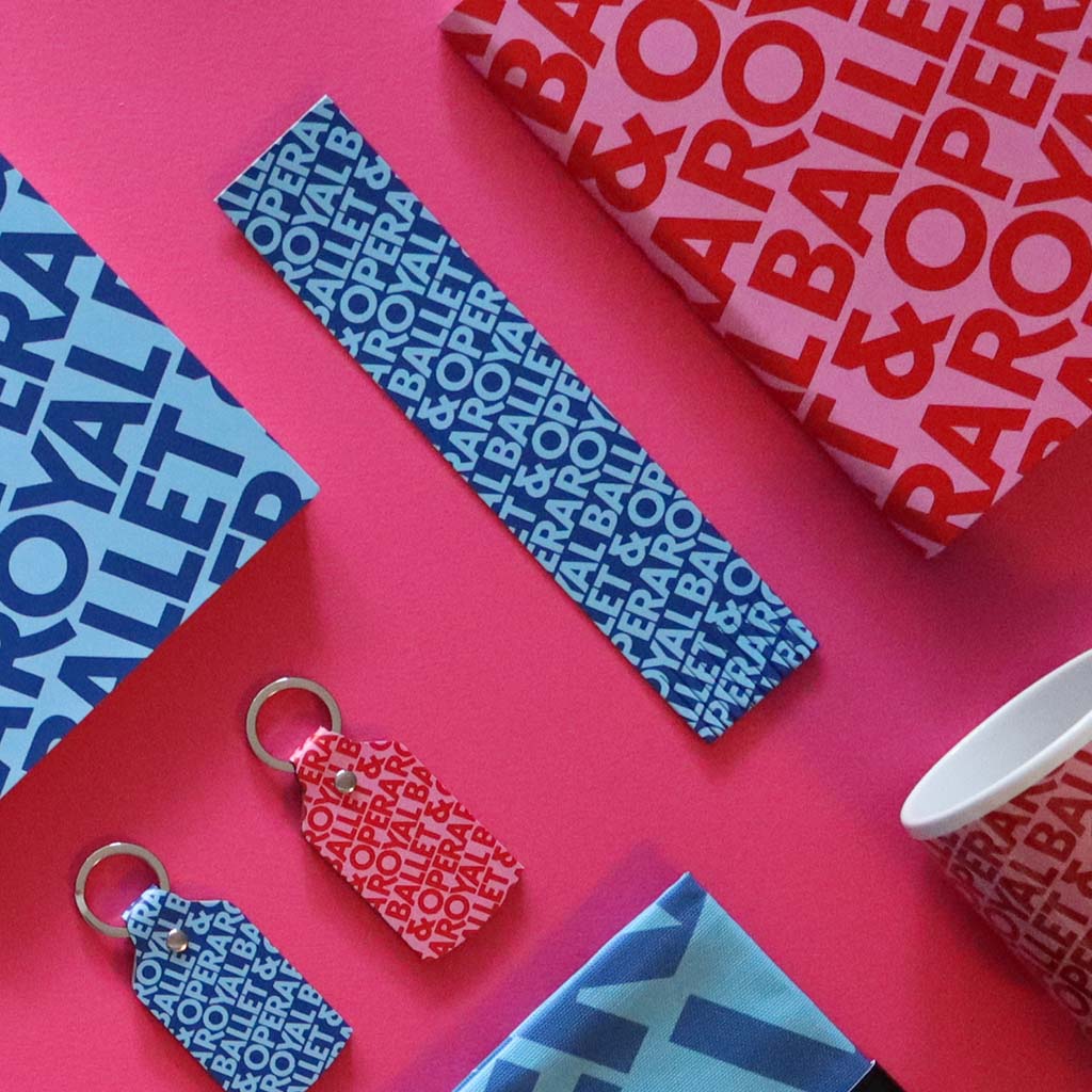 Blue signature bookmark with other items from the collection on a pink background