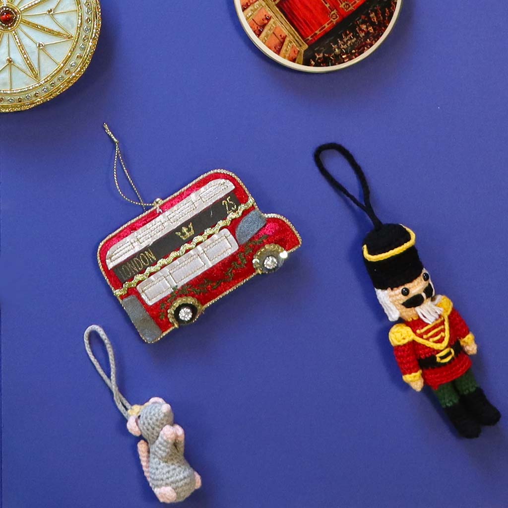 Red London bus decoration with gold accents on a white background