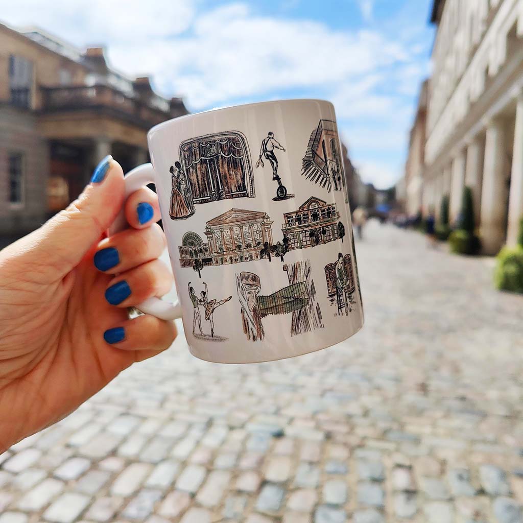 White mug with illustrations of buildings and people in Covent Garden on a white background