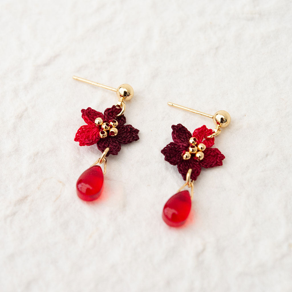 red crochet flower earrings with a red bead on gold studs