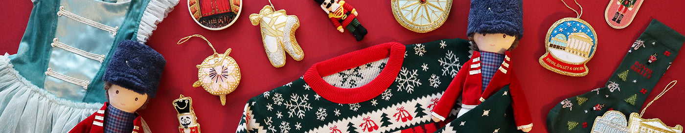 Collection of Christmas-themed items including a jumper, dress decorations, and dolls on a red background