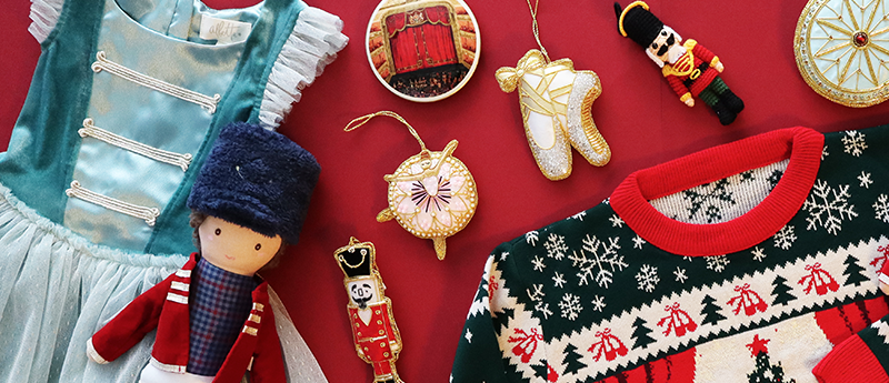Collection of Christmas-themed items including a jumper, dress decorations, and dolls on a red background
