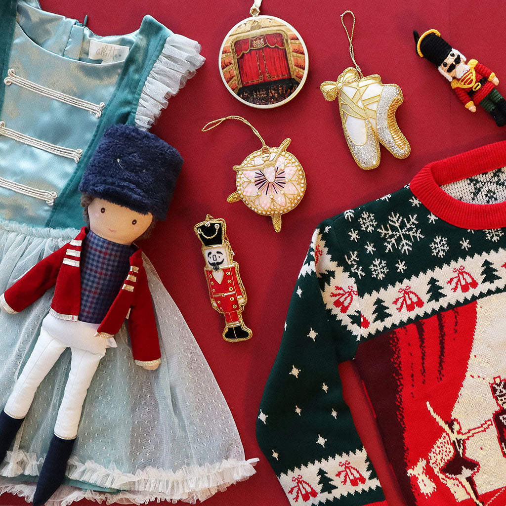 Christmas-themed items including a doll, jumper, dress, and decorations on a red background