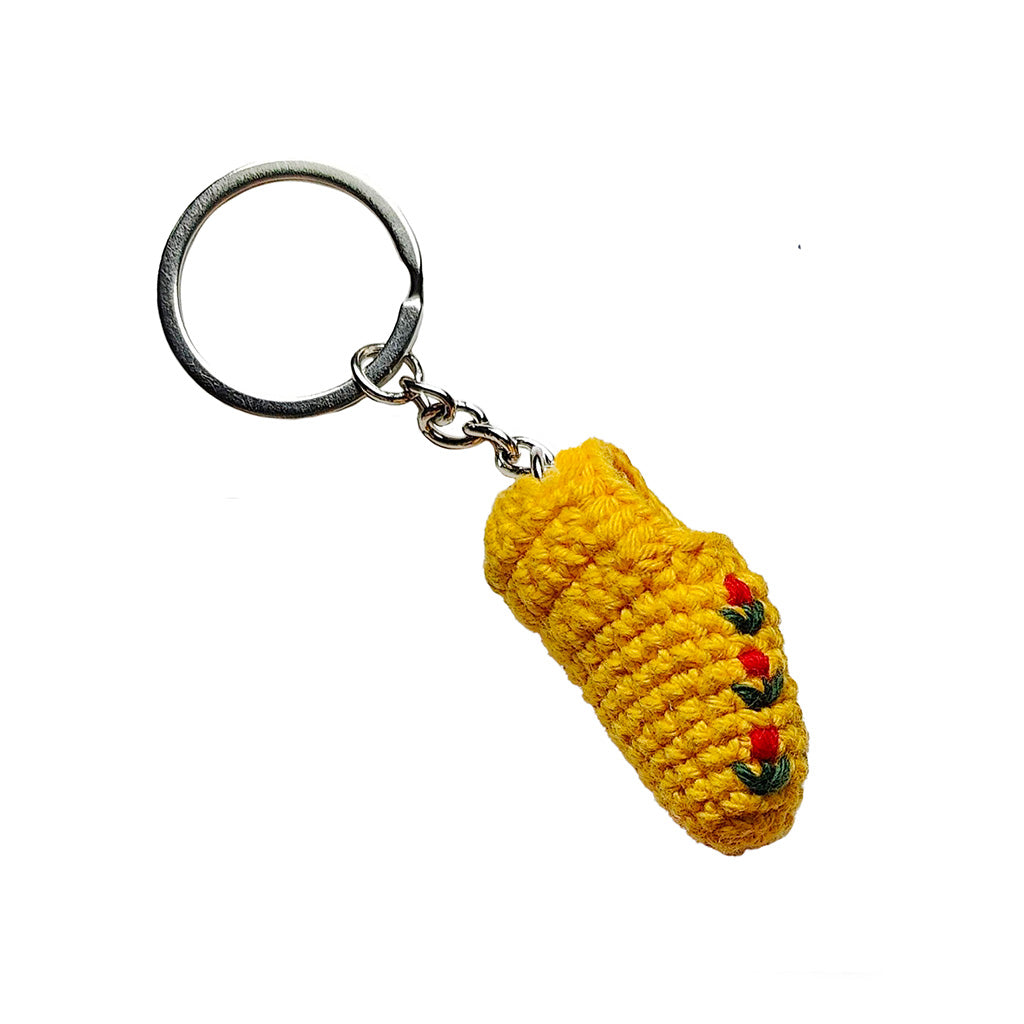 Yellow clog-shaped keychain with red and green accents on a white background
