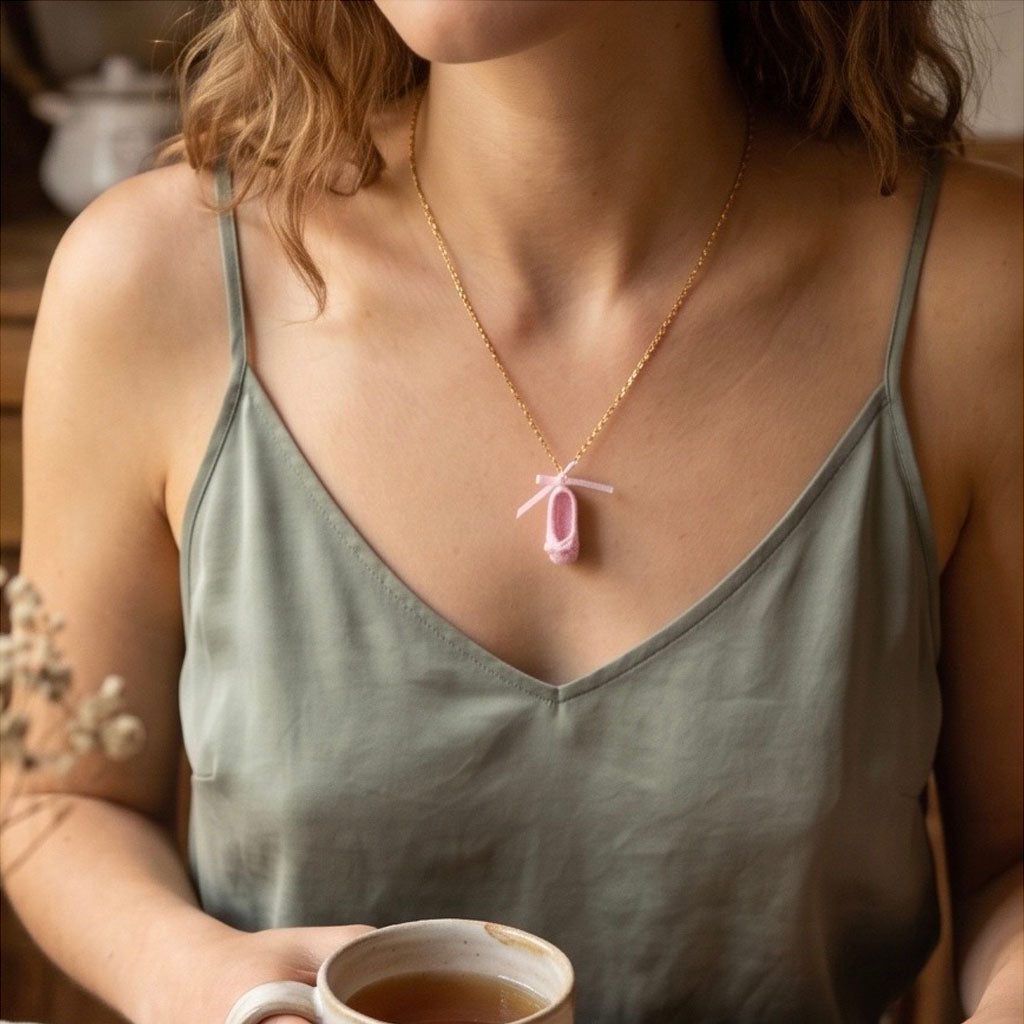Woman wearing pink crochet necklace on a gold tone chain in a home setting