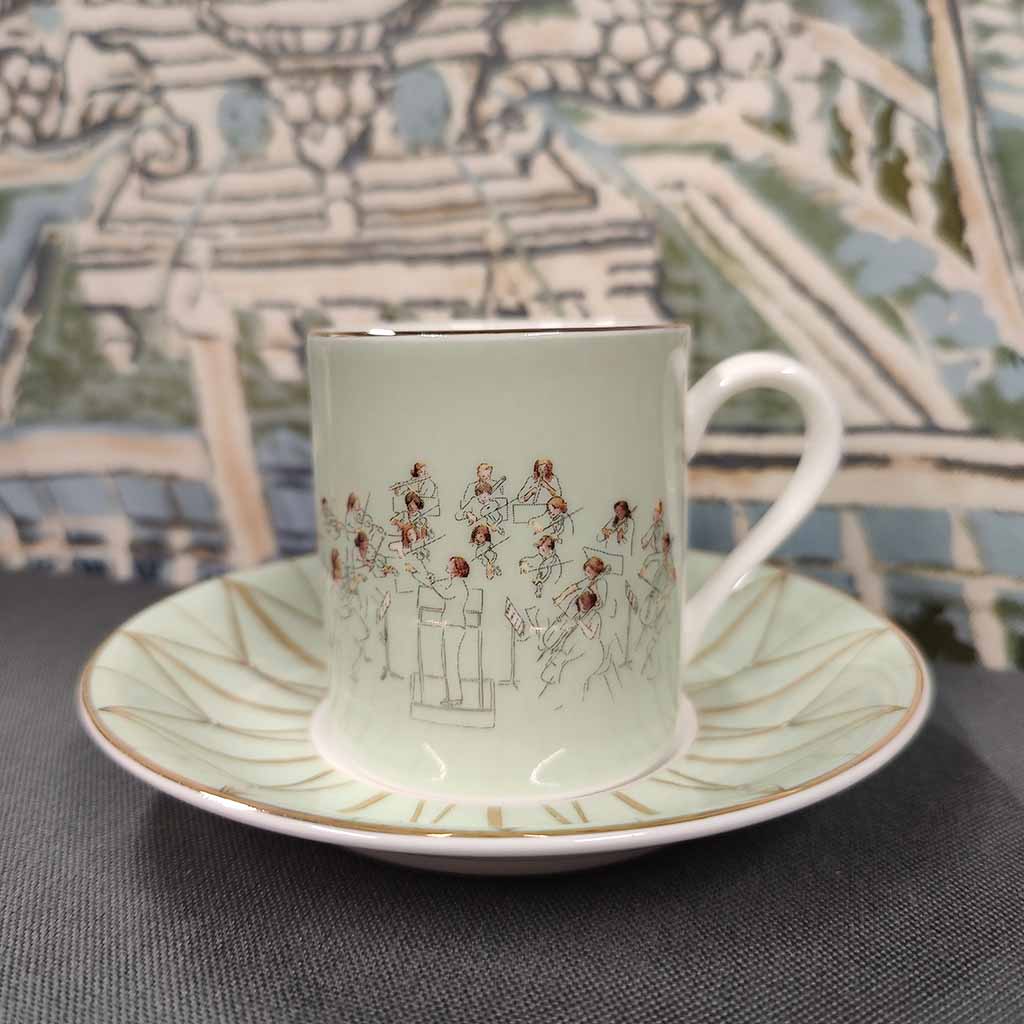 Orchestra Coffee Cup and Saucer  with patterned fabric backdrop