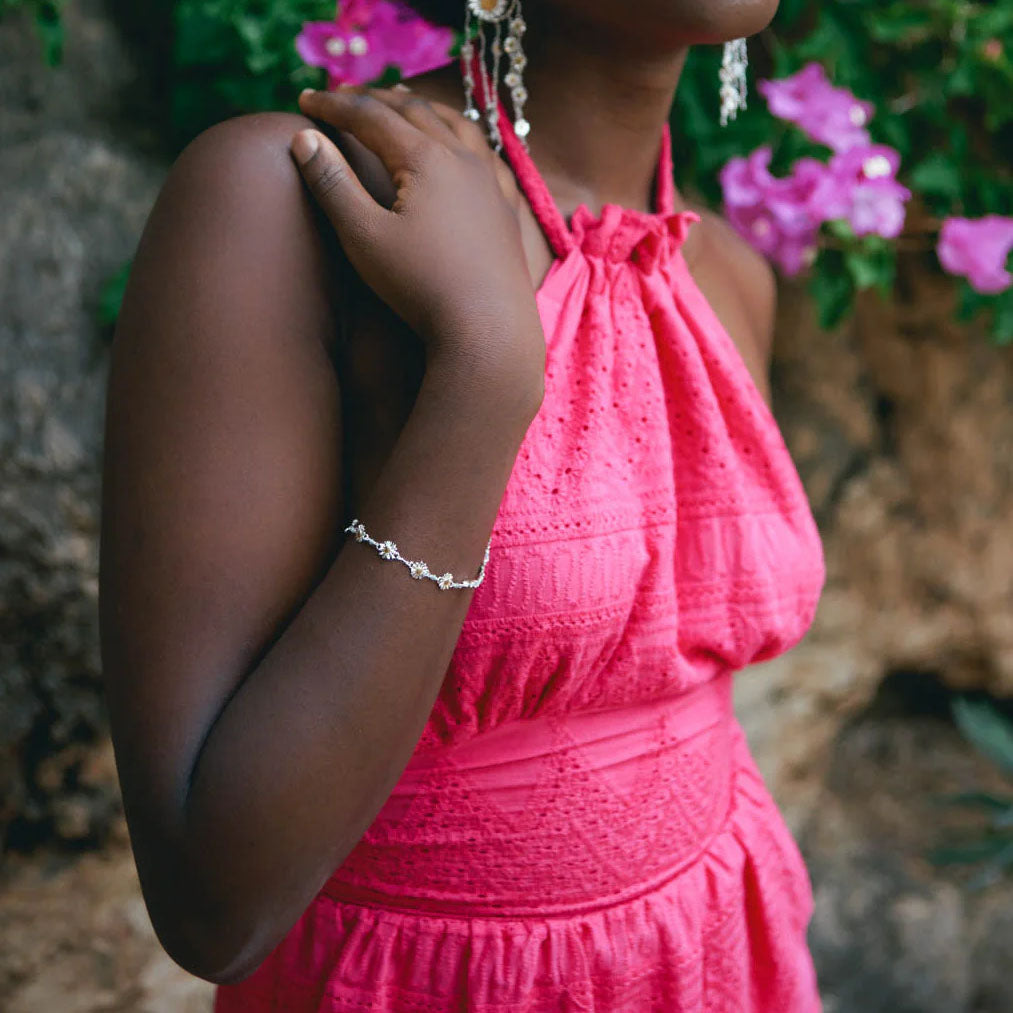 model in bright pink dress wears the daisy chain bracelet