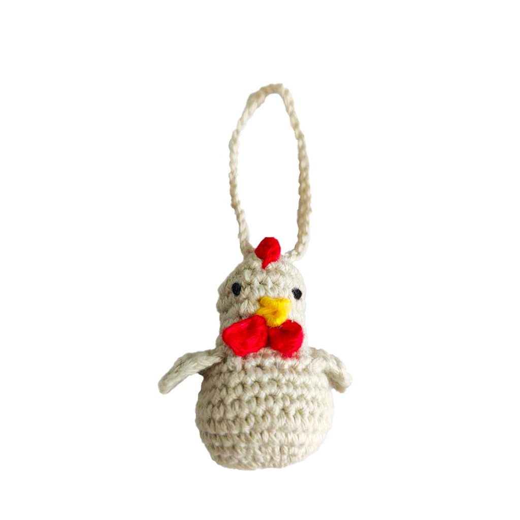 Crocheted chicken decoration with a red bow and yellow beak on a white background
