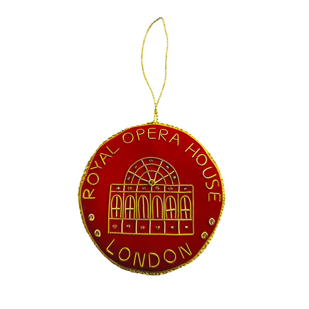 Red velvet roundel decoration with gold text &#39;Royal Opera House London &#39; and the facade of the building on a white background