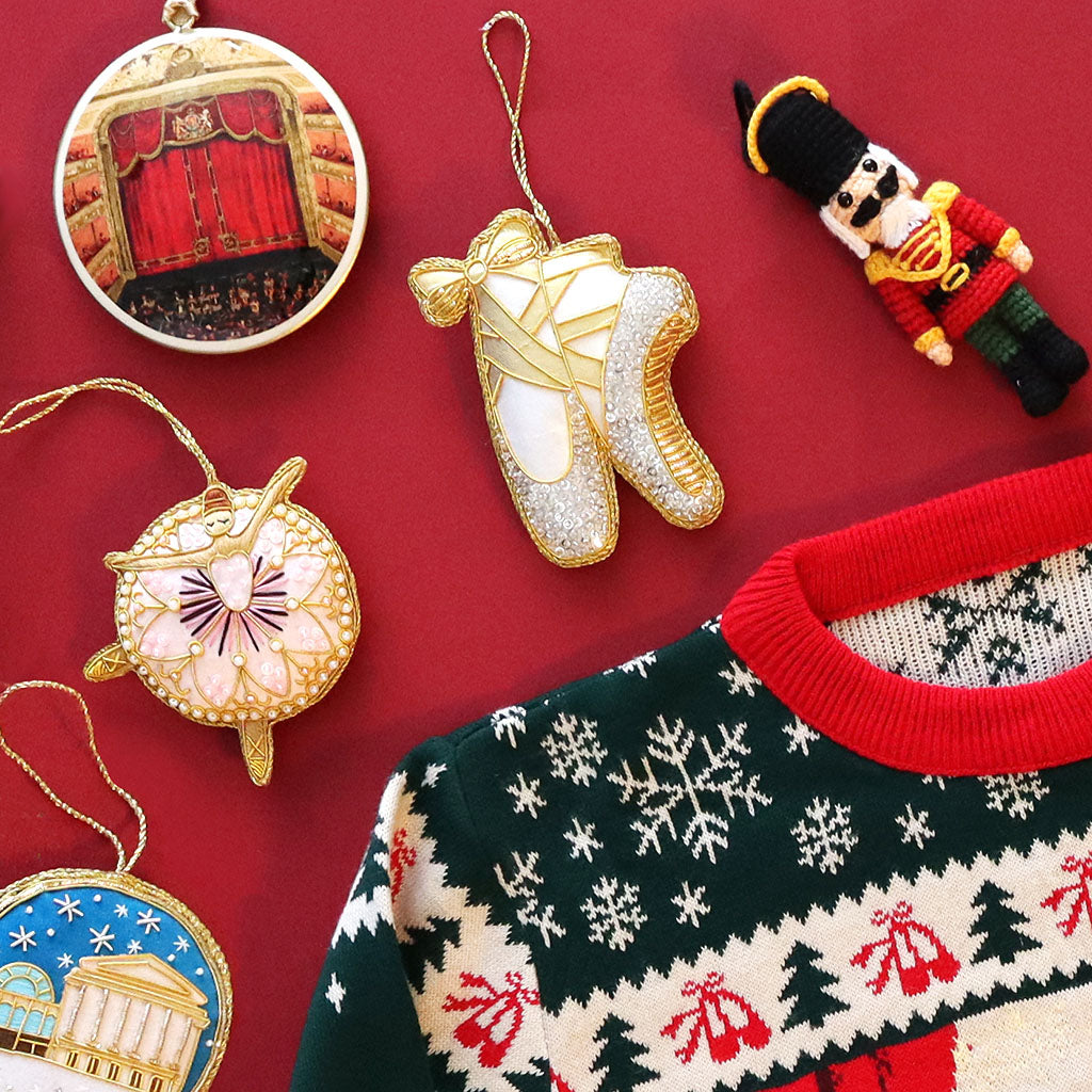 Decorative Christmas decorations and a patterned jumper on a red background
