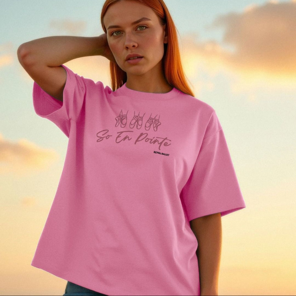245521659 Pink Printed T-shirt with pink text 'So en pointe' and black text 'Royal Ballet' on a model in front of a sunset