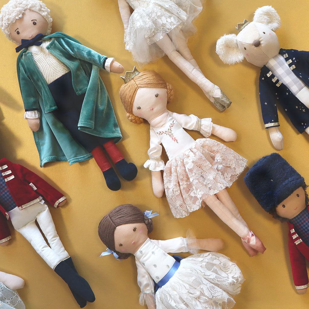Collection of handmade nutcracker themed dolls on a gold background